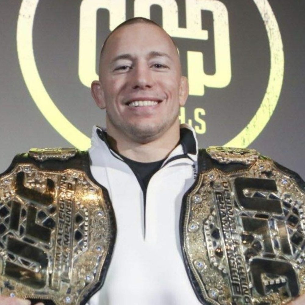 Georges St-Pierre holding his two UFC championship belts
